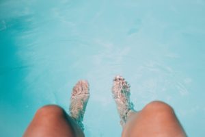 With Dolphin robotic pool cleaners, you get to spend more time enjoying your pool experience. (Pictured: feet dangling in a clear pool water)