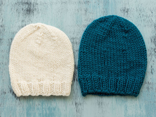 Cream Knit hat next to blue knit hat