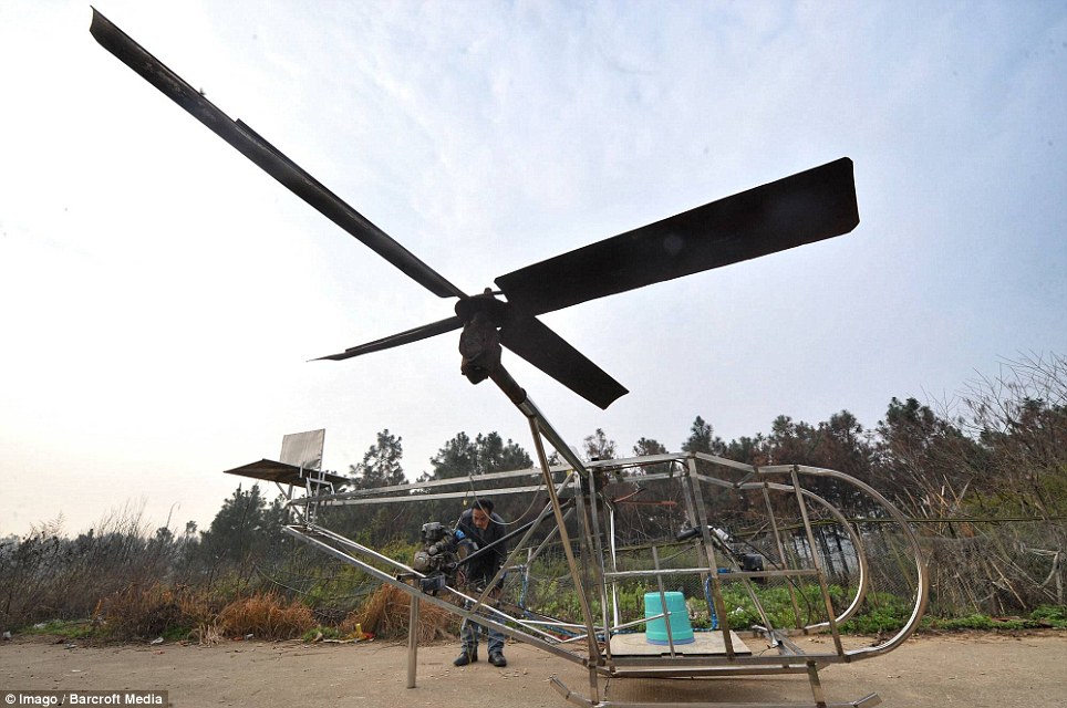 Inspirational: Farmer Li Housheng examines the engine of his makeshift helicopter in Ganzhou Village of Baitang Township, China. He said during a test flight the aircraft lifted 40cms off the ground