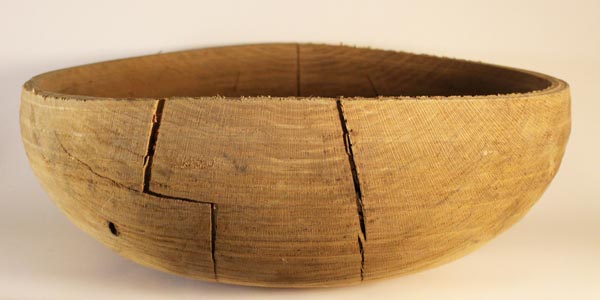 An oak bowl with massive cracks.