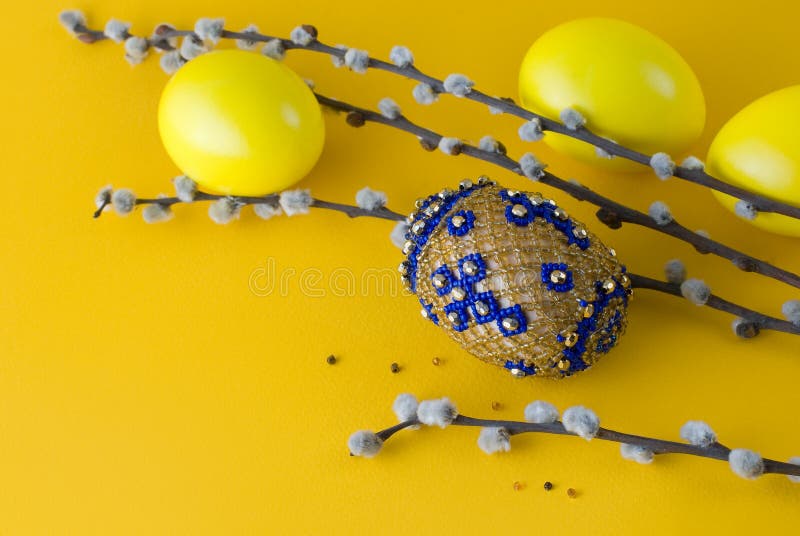 Bead easter egg and pussy-willow. Bead easter egg and sprigs of pussy-willow on a yellow background stock image