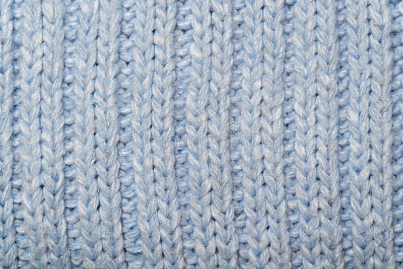 Blue knitted wool fabric background. Very warm natural knitwear handmade. Close-up to blue knitted wool fabric background. Very warm natural knitwear handmade stock images