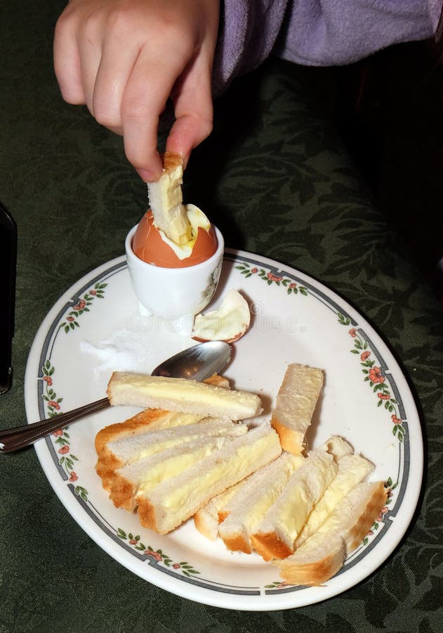 A boiled egg for breakfast. A boiled egg for breakfast with salt and bead and butter soldiers stock images