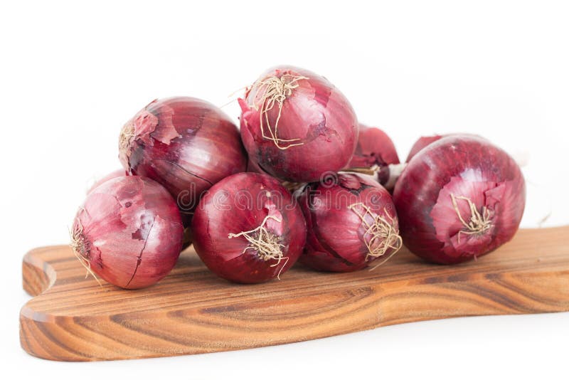 Bunch of red onions. On wooden cutting board isolated on white background stock photography
