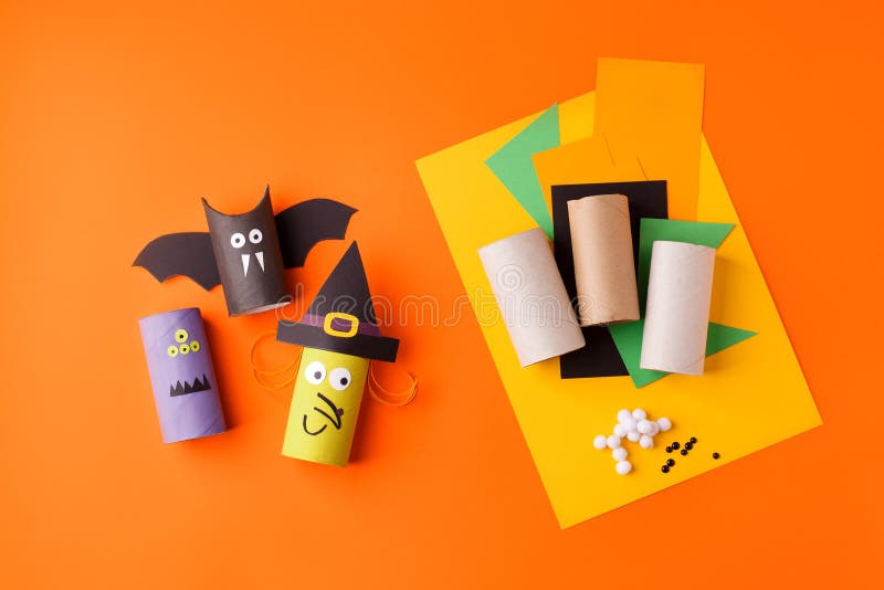 Child creates decorations for Halloween party from toilet roll. Easy eco-friendly DIY master class, craft for kids. Materials for stock image