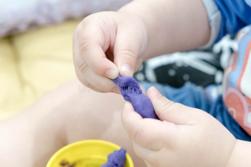 Child hands playing with colorful clay, plasticine in children`s room, Creative playing with baby play dough, hands stock photo