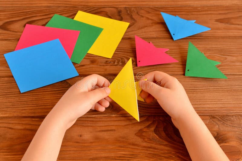 Child holds an yellow origami fish in his hands. Kids crafts idea royalty free stock photography