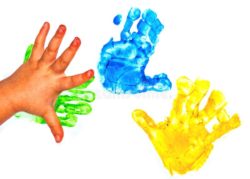 A child`s hand and multicolored painted handprints on a white background. close up royalty free stock images
