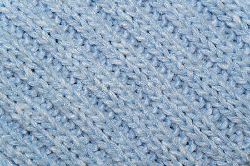 Blue knitted wool fabric background. Very warm natural knitwear handmade. Close-up to blue knitted wool fabric background. Very warm natural knitwear handmade royalty free stock photo