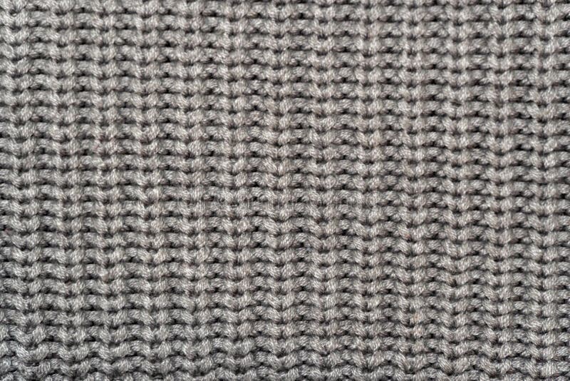 Grey knitted wool fabric background. Very warm natural knitwear handmade. Close up to grey knitted wool fabric background. Very warm natural knitwear handmade stock images