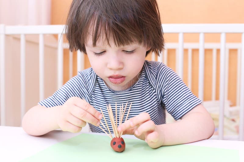 Cute 2 years child made toothpick spines by playdough hedgehog a. Cute 2 years child made toothpick spines by playdough hedgehog royalty free stock images