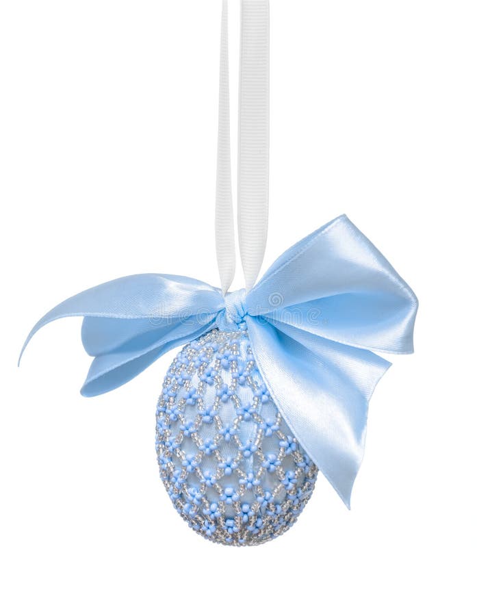 Easter egg decorated with beads and a bow on a white background. Easter egg decorated with beads and a bow in blue hues, hanging on a white background royalty free stock images