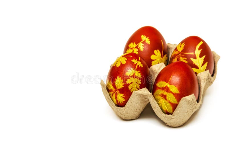 Easter eggs dyed with onion husks with a pattern of fresh leaves of plants on a white background. Creative decoration. And DIY concept. Close-up. Postcard with stock photos