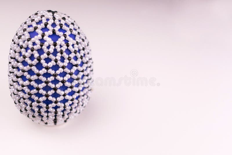 The egg is decorated with beads on a white background. Easter egg decoration. Copy space. The egg is decorated with beads on a white background.  Copy space royalty free stock images