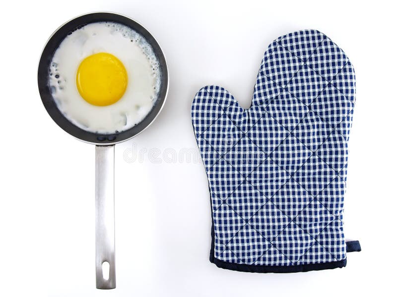 Fried egg in metal frying pan with silver stainless steel handle and blue white checkered pattern oven glove isolated on white. Background, preparation cooking royalty free stock image