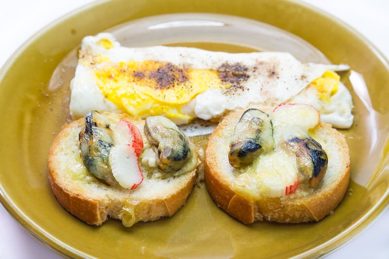 Garlic bead with sea mussel, crabmeat and egg. For breakfast royalty free stock image