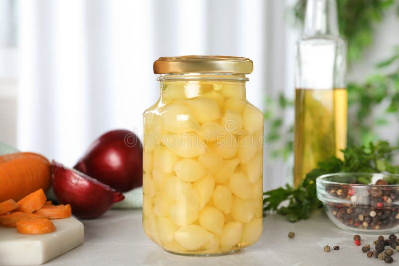 Glass jar of pickled onions on table. Glass jar of pickled onions on marble table stock photo