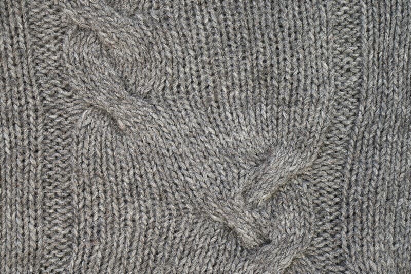 Gray knitted texture with a relief pattern. Handmade Knitwear. Background. Abstract stock photography