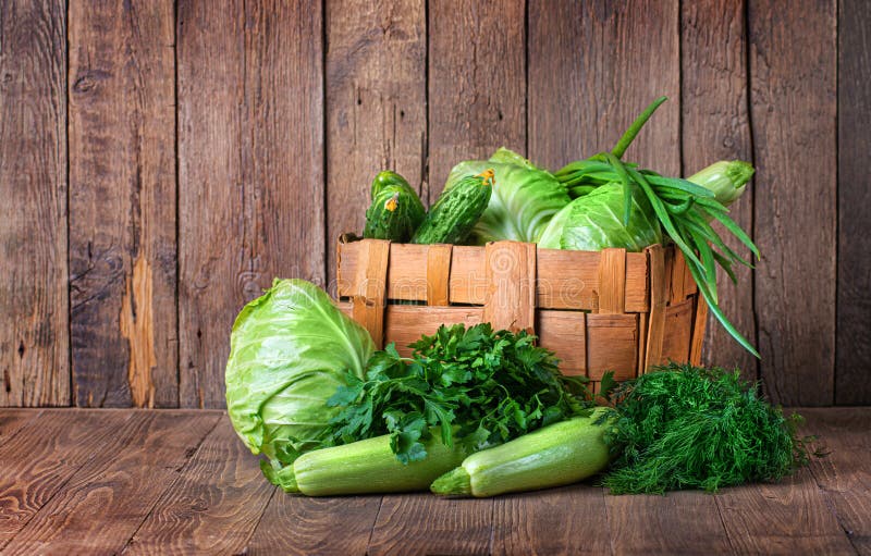 Green food. Composition with natural green vegetables. Cabbage, squash, dill, parsley and green onion are on the wooden background.  stock photos