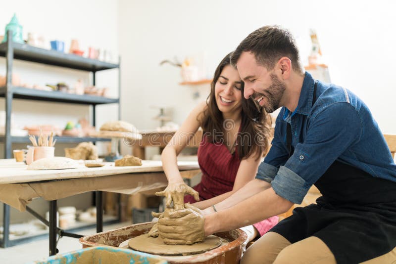 Couple Showing Their Creativity While Dating In Pottery Class. Happy mid adult couple showing their creativity while dating in pottery class stock photos