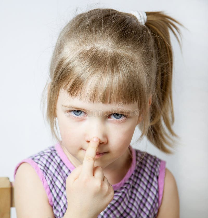 Little girl touching her nose stock photos