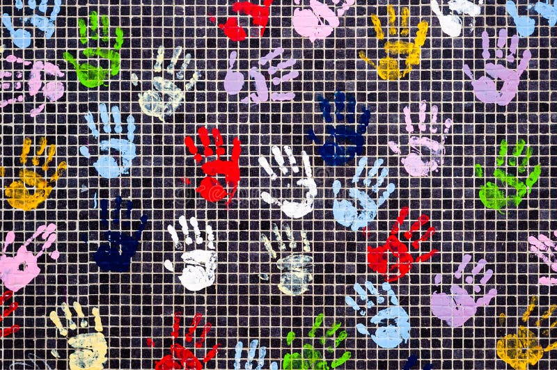 Many multicolored children handprints on a black wall. Many multicolored children handprints with finger paint on a black tiled wall royalty free illustration