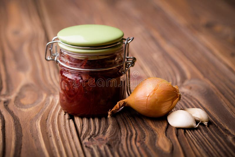 Natural diy red onion marmalade. Homemade DIY natural healthy red onion marmalade with rasberry sirup decarated with onion and garlic royalty free stock image