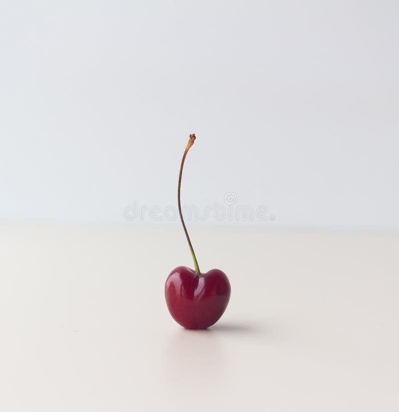 One unusual heart shaped sweet cherry. Postcard. Ugly food royalty free stock image