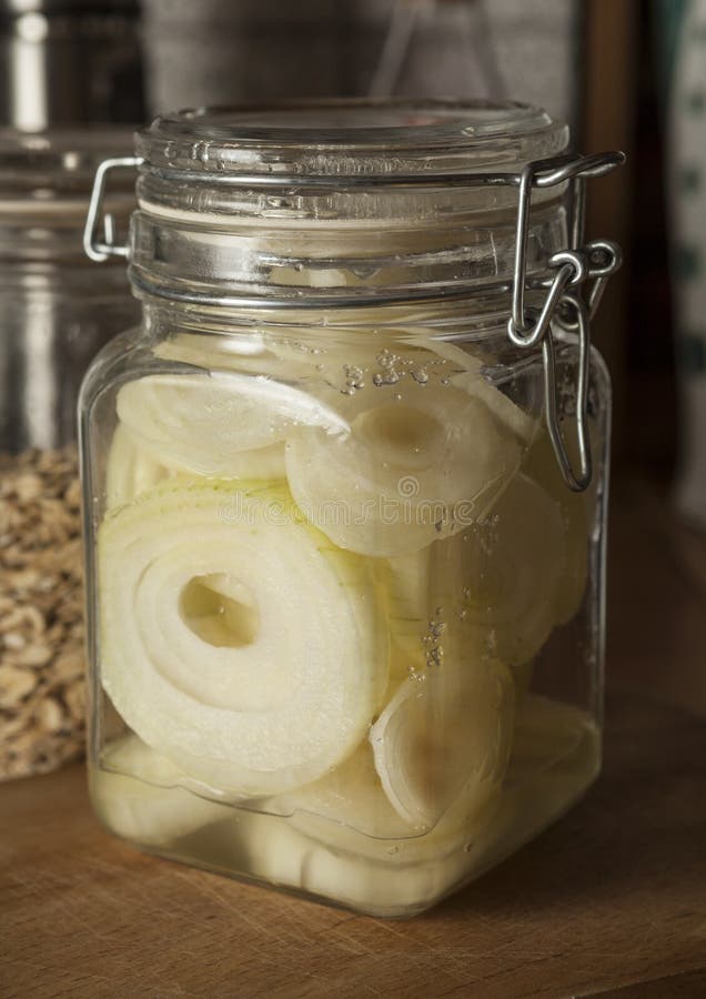 Onion syrup. Jar with raw onion slices sprinkled with sugar giving onion syrup, traditional home remedy for cough and cold stock image