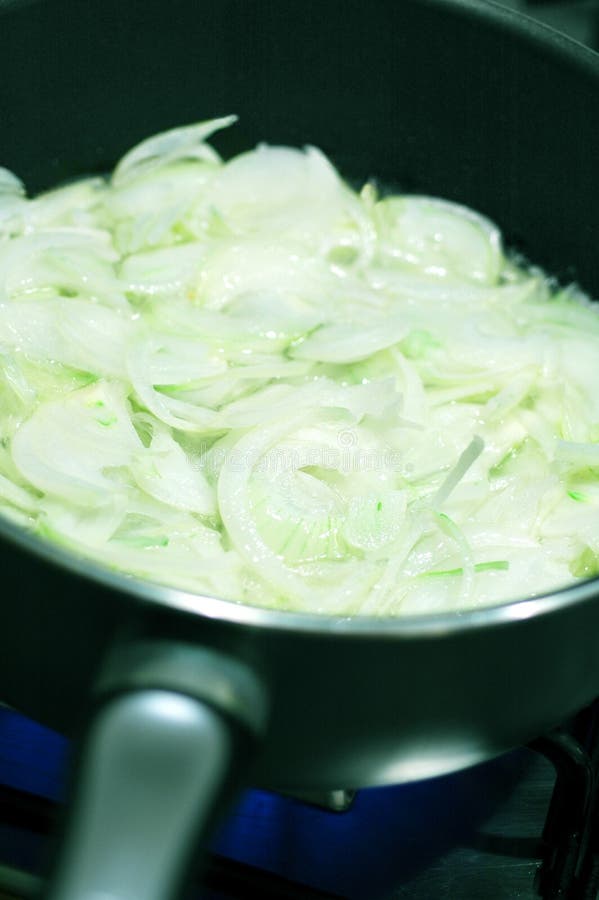 Onions. Frying onions in a pan royalty free stock image