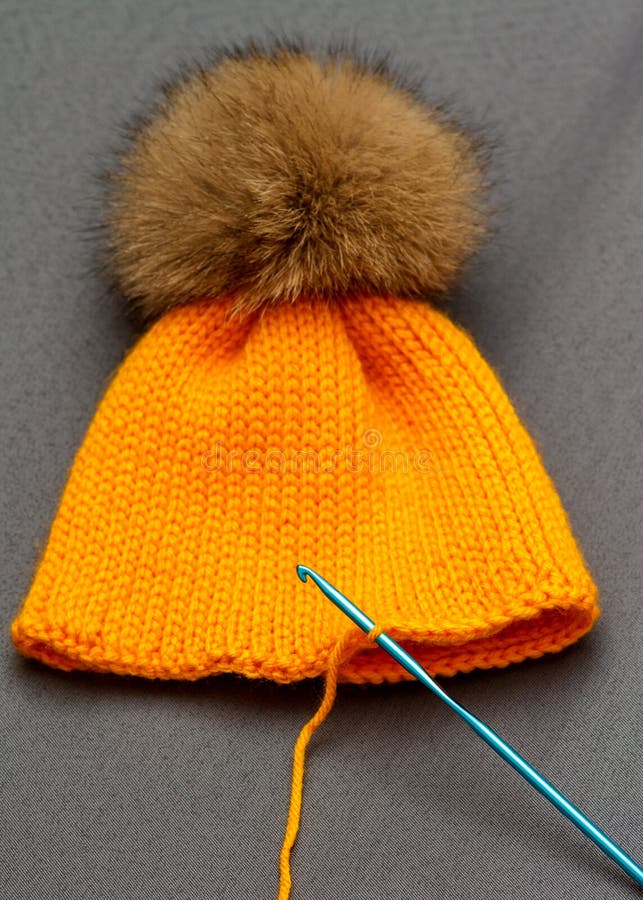 Orange handmade hat. Handmade knitwear composition with warm hat of pastel color royalty free stock image