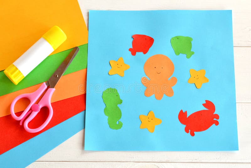 Paper applique with sea animals and fishes. Art lesson in kindergarten. Sheets of colored paper, scissors, glue royalty free stock photography