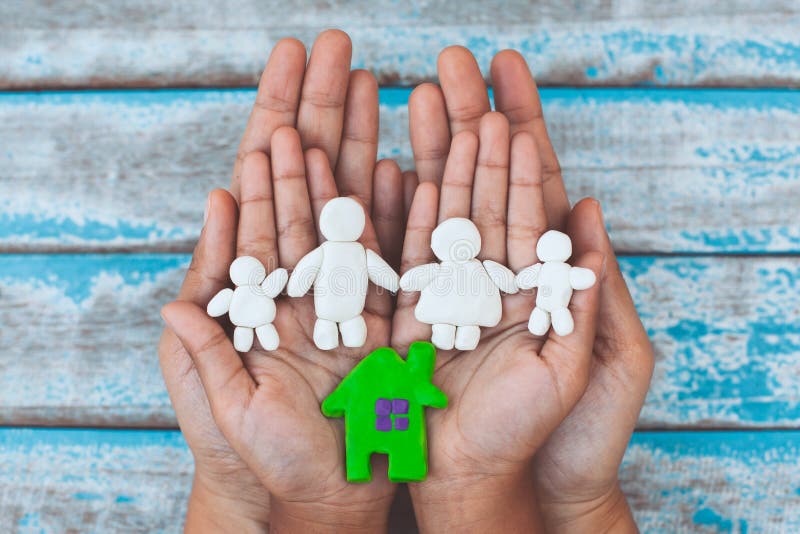 Plasticine clay happy family and house on child and parent hands.Happy family and warm house concept. Plasticine clay happy family and house on child and parent royalty free stock photos