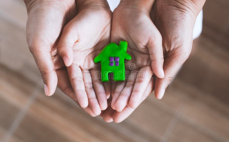 Plasticine clay house on child and parents hands.Happy family and warm house concept. Plasticine clay house on child and parents hands. Happy family and warm stock photo