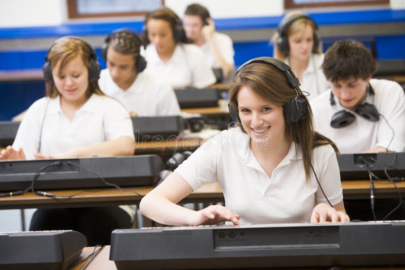 Schoolchildren practicing keyboard in music class. Schoolchildren practicing on a keyboard in music class royalty free stock photo