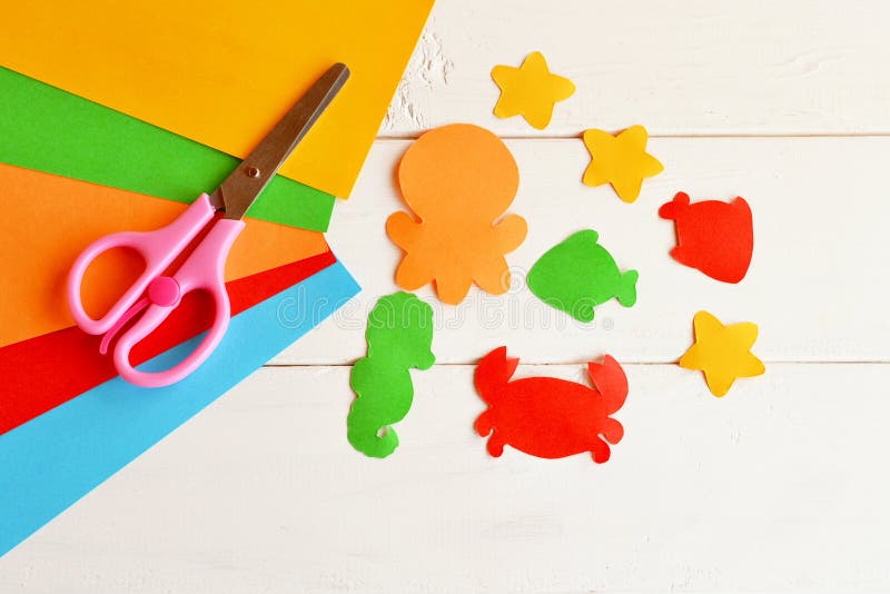 Sheets of colored paper, scissors, glue, paper fish and sea creatures. DIY concept. Easy kids craft idea. Paper craft stock image