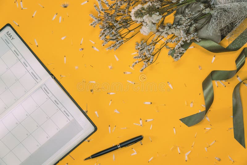 Top view concept of pastel yellow background. concept postcard flowers with a notebook pen placed. yellow background concept. Postcard of white flower bouquet royalty free stock photo