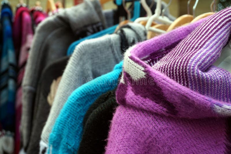 Traditional multi colored woolen knitwear clothes for sale on a market stall stock images
