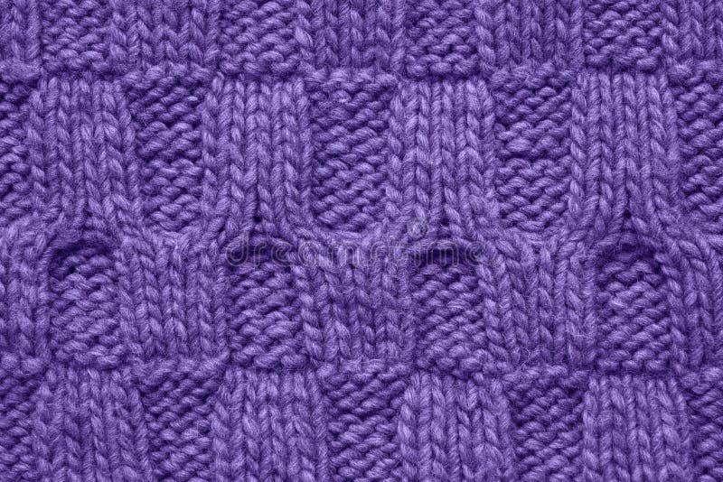 Violet knitted texture with a relief pattern. Handmade Knitwear. Background. Color of the year 2019 concept. Ultra violet colored knitted texture with a relief stock photography