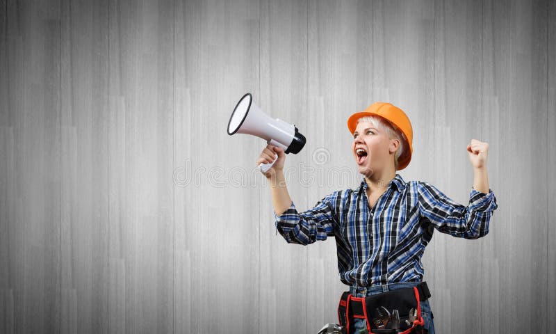 Woman builder with megaphone stock photo