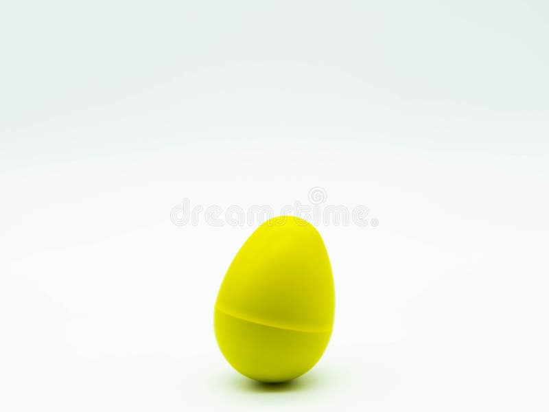 Yellow egg shaker on white background at the bottom of the image with space at the top. Percussion instrument concept. Yellow egg shaker on a white background at royalty free stock images