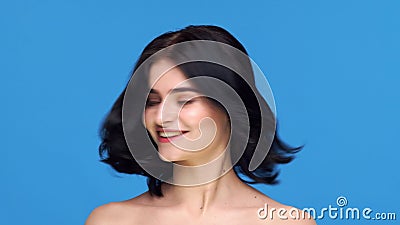 Studio portrait of young and beautiful brunette woman over blue background. Skin care, health, makeup and cosmetics. stock video footage